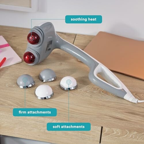 Handheld massager with firm and soft attachments on a table.