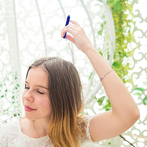 Woman using a head massager in a decorative setting