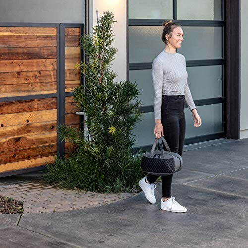 Woman walking with a gym bag near a modern building